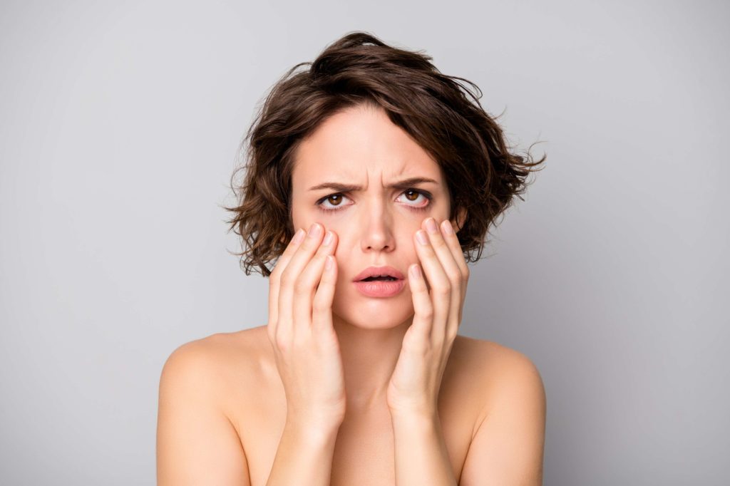 Woman Checking Dark Circles on the Mirror | Skynn MD in Holly Springs, NC