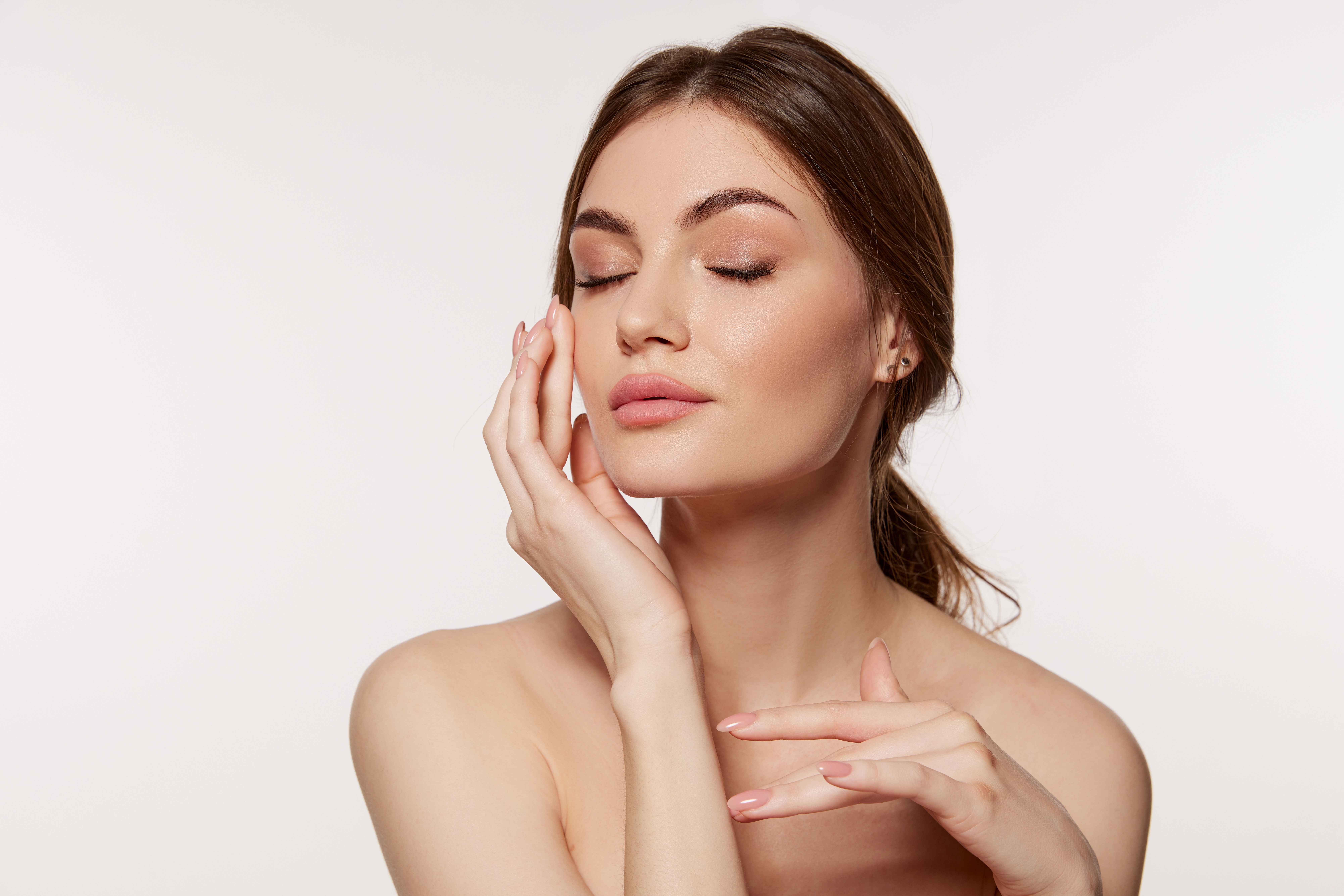 Closed Eye Young Woman Touches her Skin With Hand | Skynn MD in Holly Springs, NC